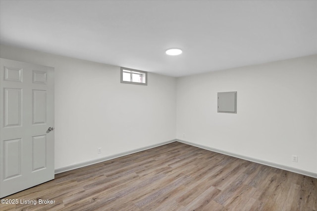 basement with electric panel, baseboards, and wood finished floors