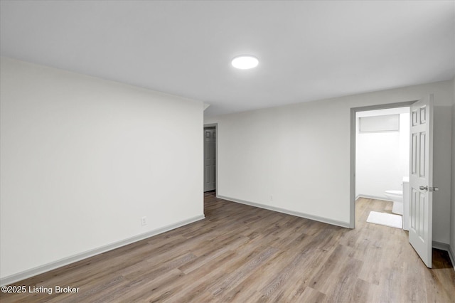 spare room with wood finished floors and baseboards