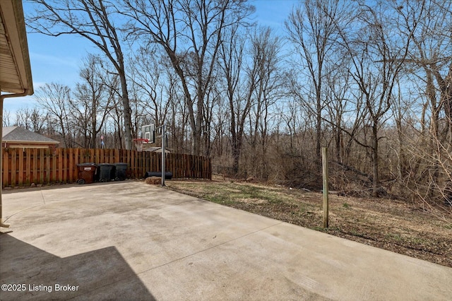 view of patio / terrace with basketball hoop and fence