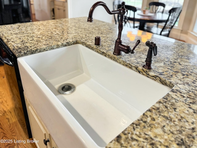 interior details with light stone counters and a sink