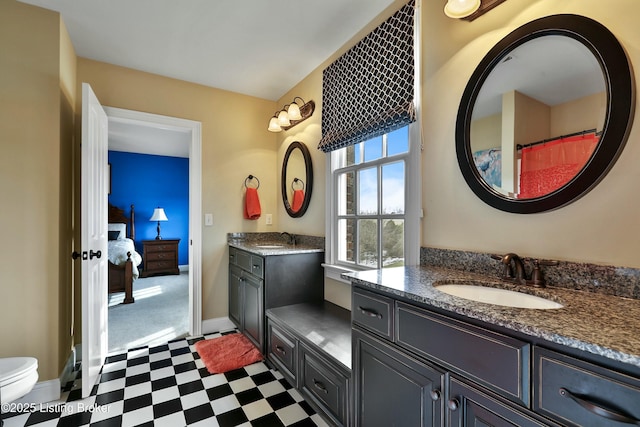 bathroom with two vanities, a sink, baseboards, and tile patterned floors