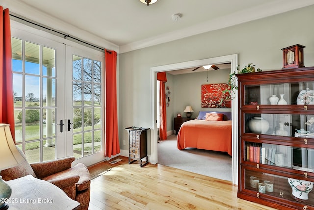 bedroom with baseboards, french doors, wood finished floors, and crown molding