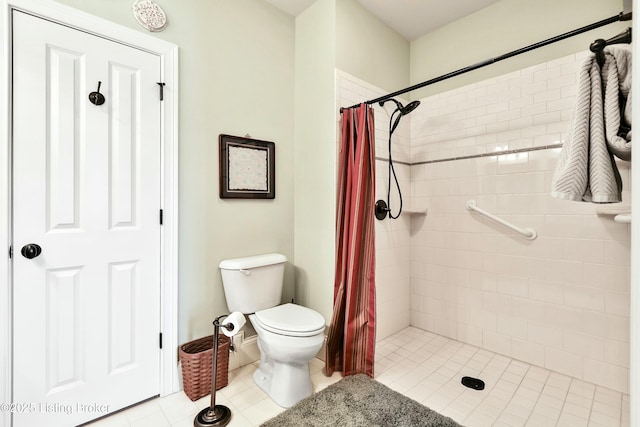 bathroom featuring a tile shower and toilet