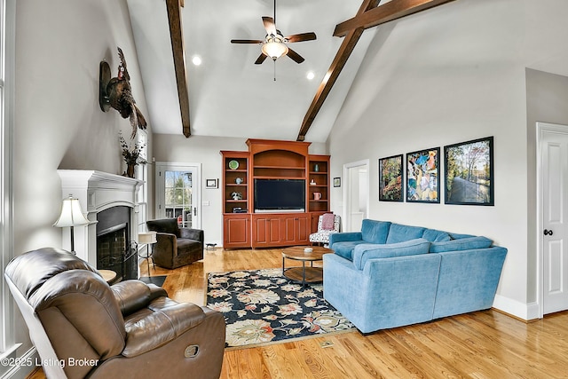 living room featuring high vaulted ceiling, beamed ceiling, a fireplace, and light wood-style flooring