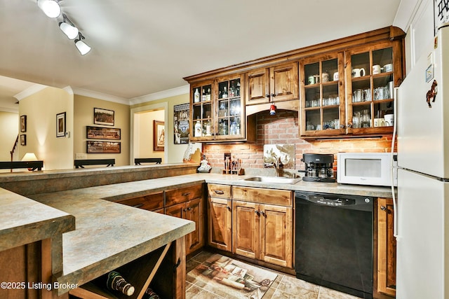 kitchen with white appliances, a sink, tasteful backsplash, brown cabinetry, and crown molding