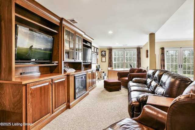 living room featuring ornamental molding, french doors, carpet, and visible vents