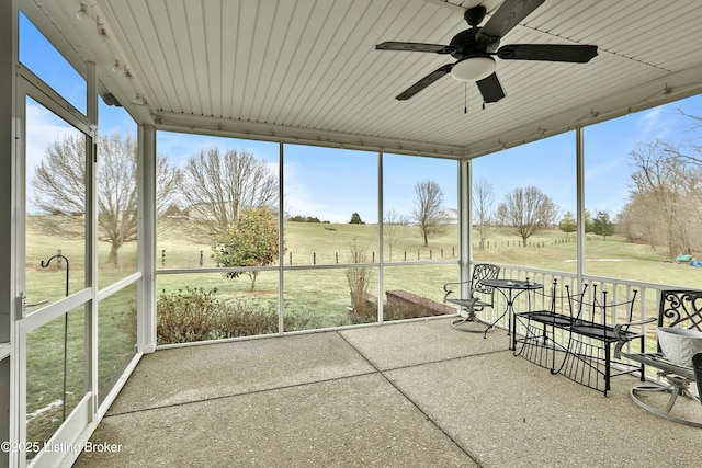 unfurnished sunroom with a rural view and a ceiling fan