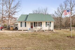 view of front of home featuring metal roof and a front yard