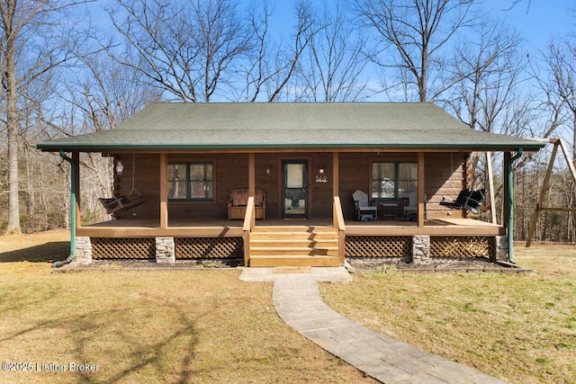 view of front of home with covered porch, a shingled roof, and a front yard