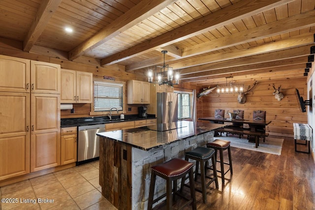 kitchen featuring wooden ceiling, an inviting chandelier, stainless steel appliances, a kitchen bar, and a sink