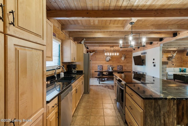 kitchen featuring wooden walls, beamed ceiling, a sink, stainless steel appliances, and a notable chandelier