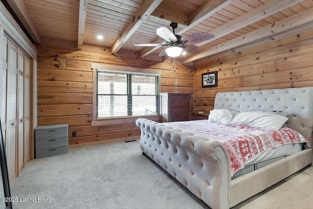 carpeted bedroom with ceiling fan, beam ceiling, wood ceiling, and wooden walls