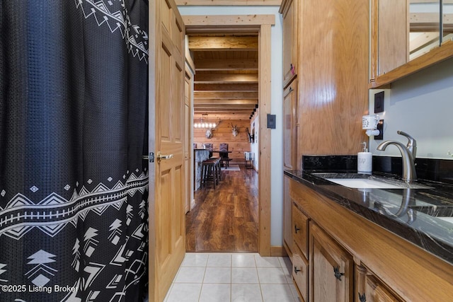 interior space with wood walls, tile patterned flooring, and vanity