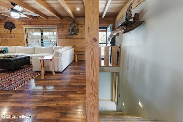 living area featuring wooden ceiling, beamed ceiling, and wooden walls