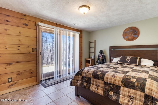 bedroom featuring light tile patterned floors, multiple windows, and a textured ceiling