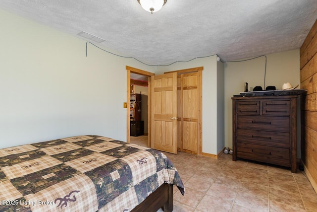 bedroom featuring light tile patterned floors and a textured ceiling