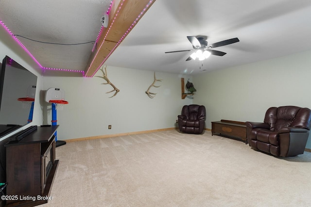 living area featuring ceiling fan, carpet, and baseboards