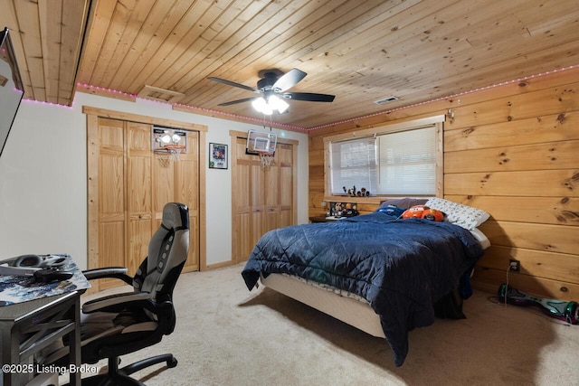 bedroom featuring wood ceiling, light colored carpet, visible vents, and two closets