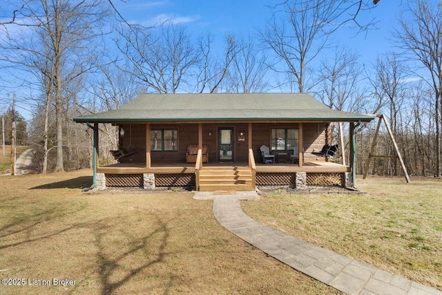 view of front of home featuring covered porch, a front lawn, and roof with shingles