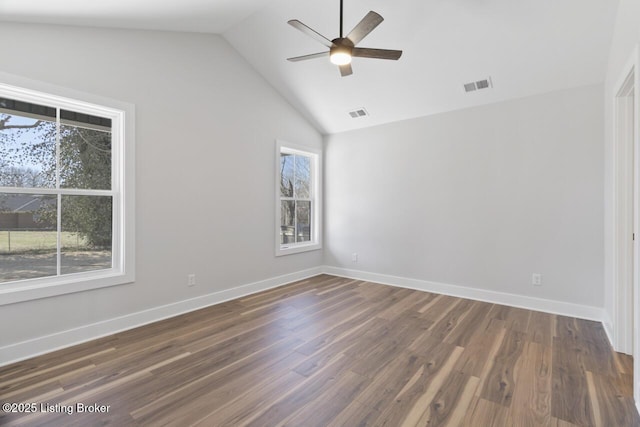 unfurnished room featuring lofted ceiling, visible vents, baseboards, and wood finished floors