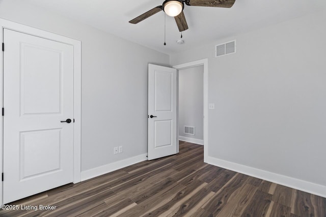 unfurnished bedroom featuring a ceiling fan, visible vents, dark wood finished floors, and baseboards