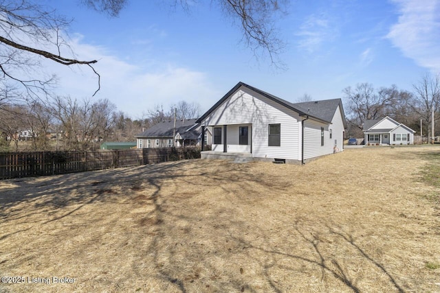 back of house with fence and a yard