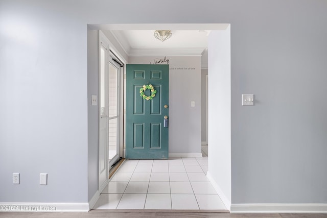 foyer entrance with light tile patterned floors, baseboards, and crown molding