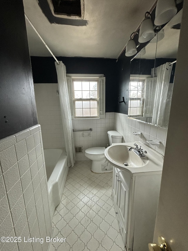 full bath with shower / tub combo, visible vents, toilet, vanity, and tile walls