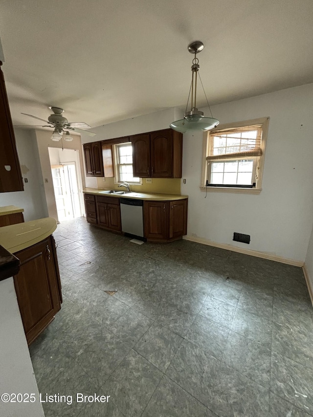 kitchen with a sink, a ceiling fan, baseboards, hanging light fixtures, and stainless steel dishwasher