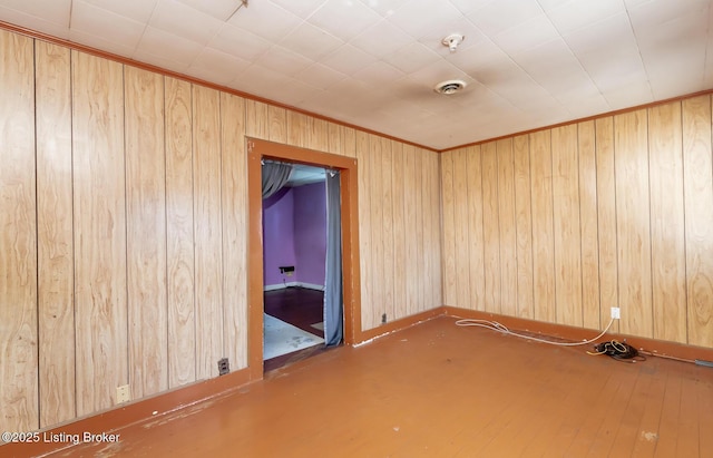 spare room featuring visible vents and wooden walls