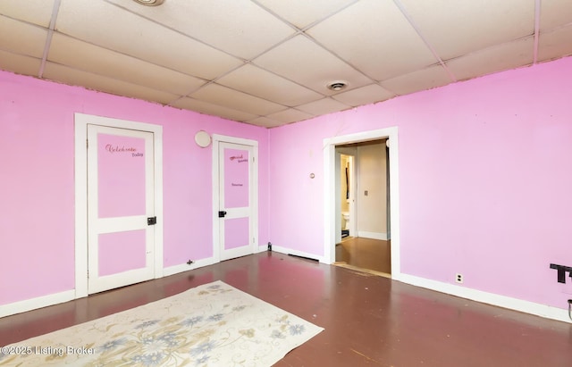 unfurnished room with visible vents, a paneled ceiling, and baseboards