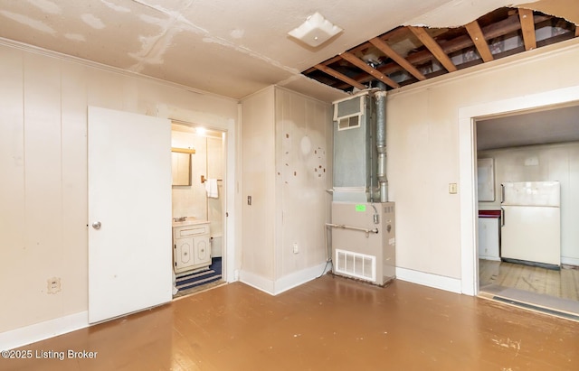 interior space featuring baseboards, heating unit, visible vents, and finished concrete floors