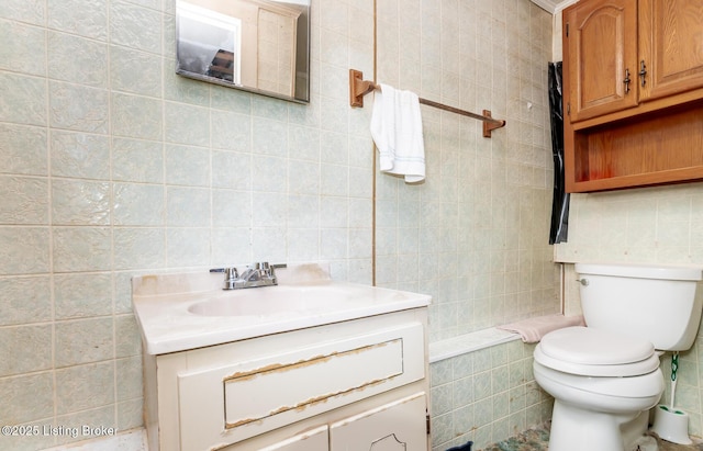 bathroom with tile walls, toilet, and vanity