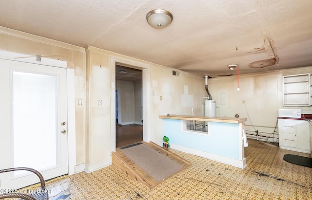 kitchen with water heater, visible vents, a textured ceiling, and tile patterned floors