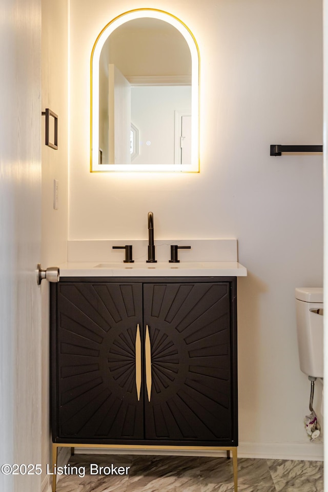 bathroom with toilet, baseboards, and a sink