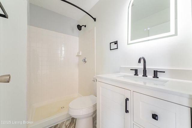 full bath with a stall shower, vanity, and toilet