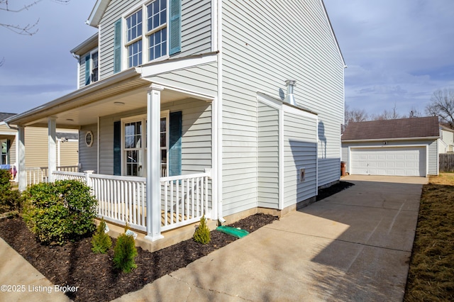 view of property exterior featuring a porch, an outdoor structure, and a detached garage