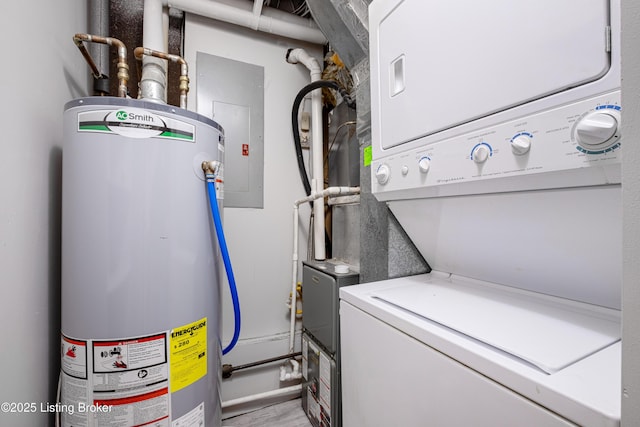 laundry room featuring water heater, stacked washer and dryer, and laundry area