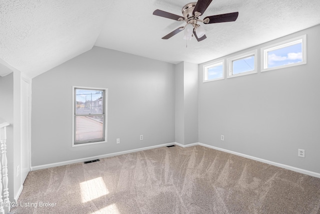 interior space featuring lofted ceiling, a wealth of natural light, visible vents, and a textured ceiling