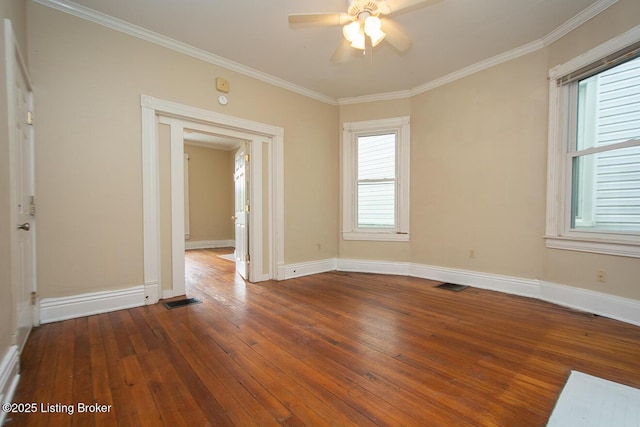 spare room with dark wood-style flooring, visible vents, and crown molding