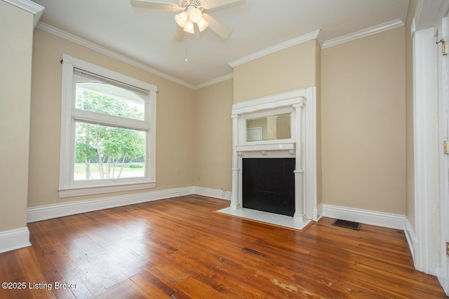 unfurnished living room with visible vents, baseboards, hardwood / wood-style flooring, a fireplace with flush hearth, and ornamental molding