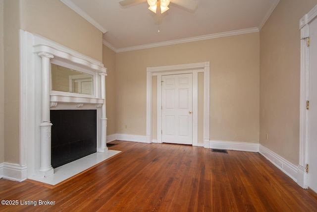 unfurnished living room featuring dark wood-type flooring, crown molding, and baseboards