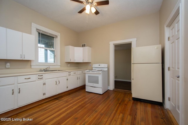 kitchen featuring light countertops, white appliances, white cabinets, and a sink