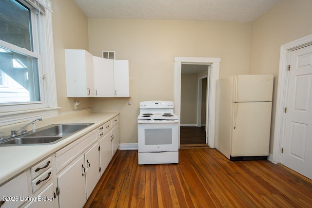 kitchen featuring light countertops, white appliances, a sink, and white cabinetry