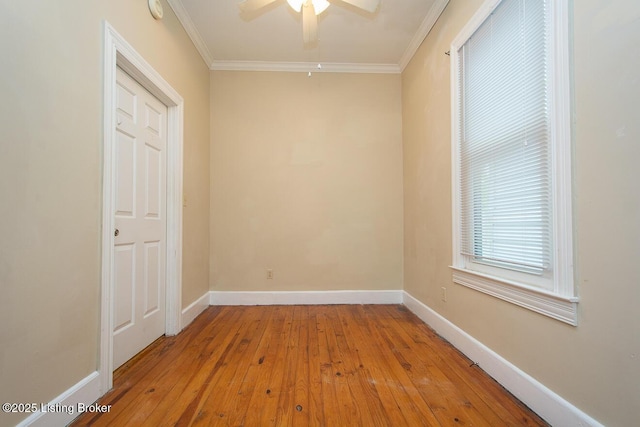 empty room featuring ornamental molding, light wood-style flooring, and baseboards