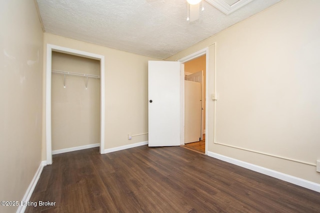 unfurnished bedroom featuring ceiling fan, a textured ceiling, baseboards, a closet, and dark wood-style floors