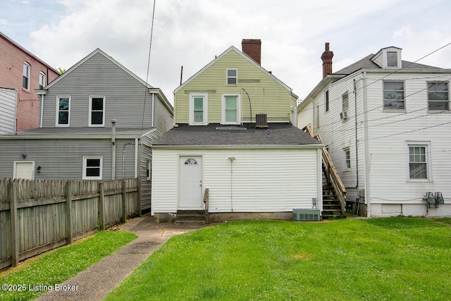 back of house featuring entry steps, cooling unit, fence, and a lawn