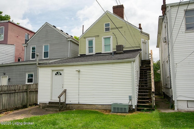 back of house with entry steps, stairs, central AC unit, and fence