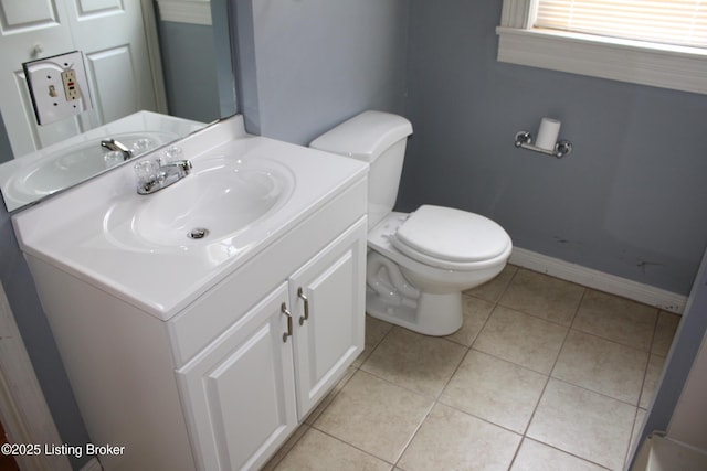 bathroom featuring toilet, baseboards, vanity, and tile patterned floors