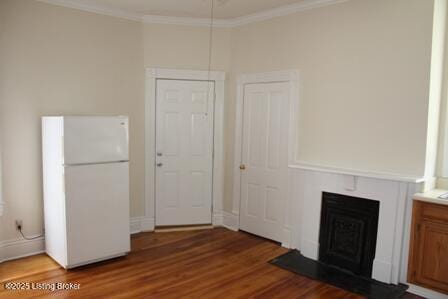 unfurnished living room with a fireplace with flush hearth, crown molding, and wood finished floors